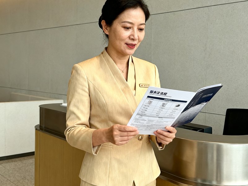 运营总监林静女士，四十岁左右，穿着米色职业套装，站在深圳北站贵宾厅前台，手中拿着一份服务流程手册，表情专注。